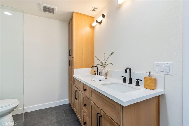 bathroom featuring visible vents, a sink, toilet, and double vanity