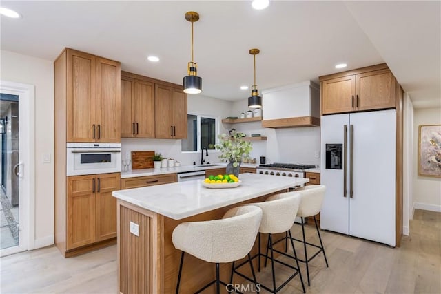 kitchen with white appliances, light wood-style flooring, custom exhaust hood, and open shelves