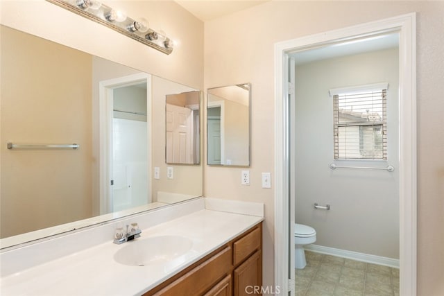 bathroom with tile patterned floors, vanity, toilet, and baseboards