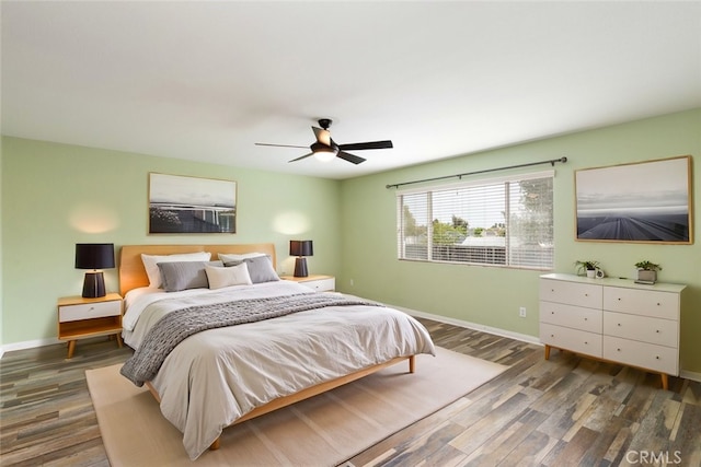 bedroom featuring ceiling fan, baseboards, and wood finished floors