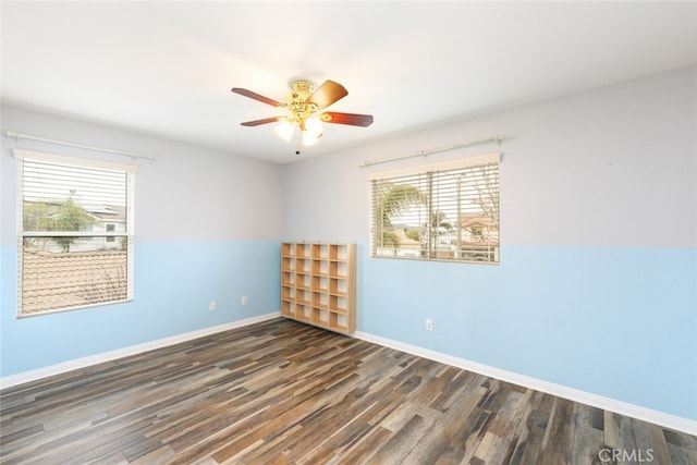 empty room with ceiling fan, baseboards, and wood finished floors