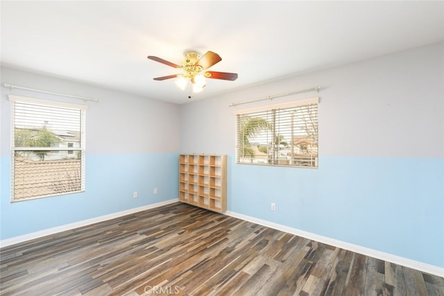 unfurnished room with wood finished floors, a ceiling fan, and baseboards