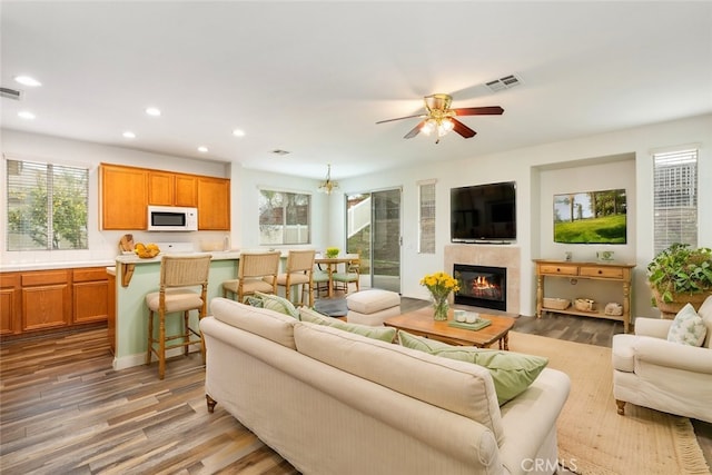 living room featuring recessed lighting, a ceiling fan, visible vents, and wood finished floors