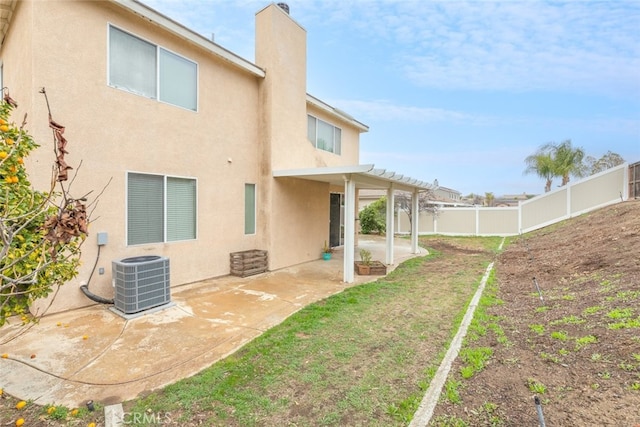 back of property with central AC, a fenced backyard, stucco siding, and a patio area