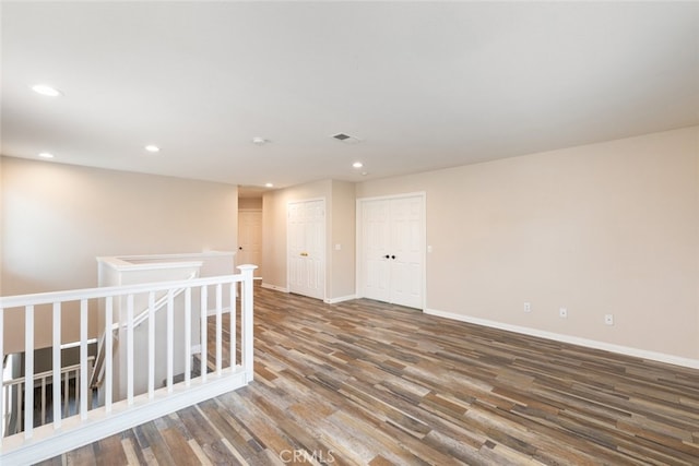 empty room featuring wood finished floors, recessed lighting, visible vents, and baseboards