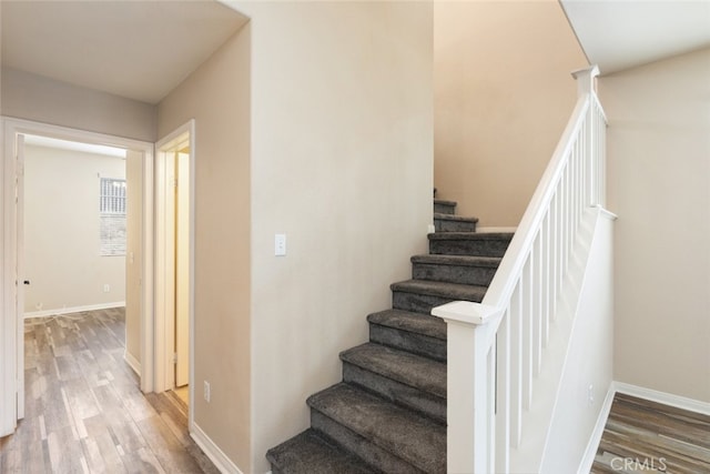 stairs with baseboards and wood finished floors