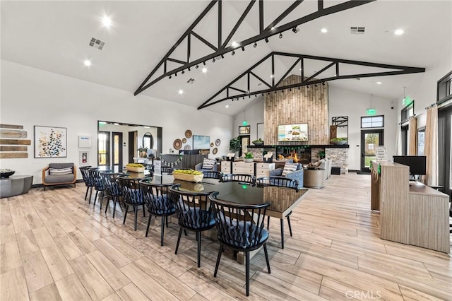 dining space featuring wood finish floors, visible vents, and a multi sided fireplace