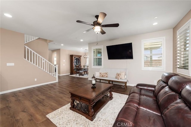 living room featuring baseboards, stairway, wood finished floors, and recessed lighting