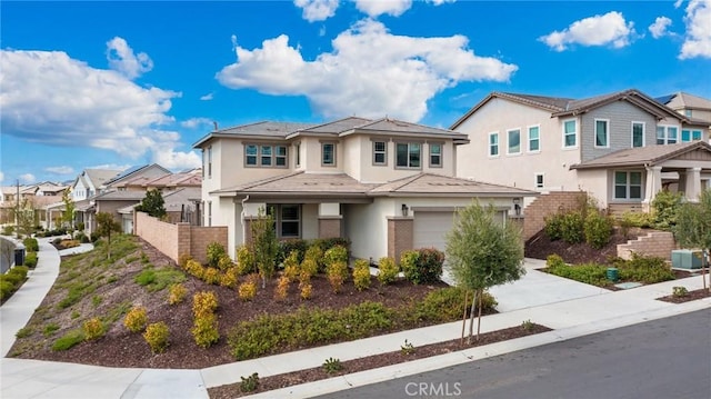 prairie-style home featuring a garage, concrete driveway, a residential view, fence, and stucco siding