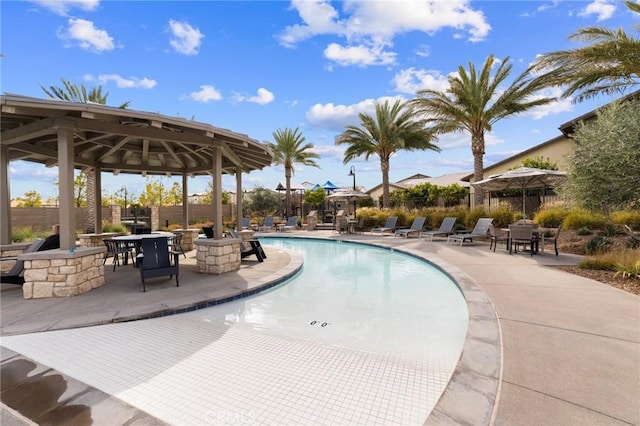 community pool with a patio, a gazebo, and fence