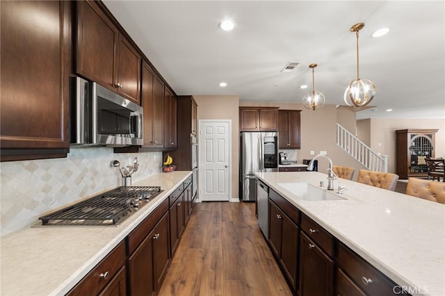 kitchen featuring stainless steel appliances, dark wood-style flooring, a sink, visible vents, and light countertops