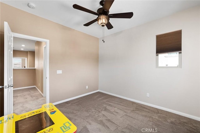 empty room with a healthy amount of sunlight, carpet, baseboards, and ceiling fan