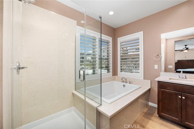 ensuite bathroom featuring a stall shower, connected bathroom, vanity, wood finished floors, and a bath