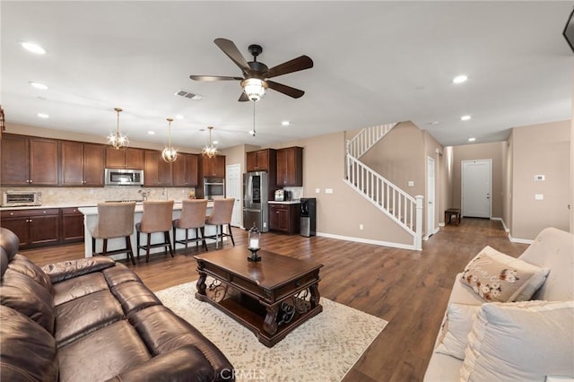 living area featuring dark wood-style flooring, stairway, visible vents, and recessed lighting