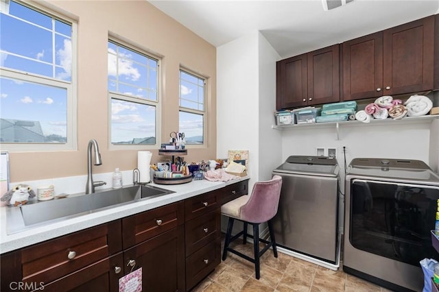 laundry area with washer and dryer, visible vents, a sink, and cabinet space