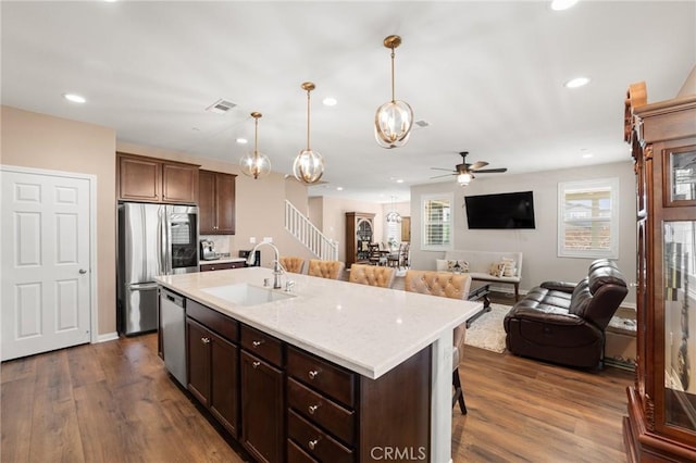 kitchen featuring appliances with stainless steel finishes, dark wood finished floors, visible vents, and a sink