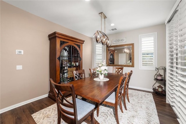 dining room featuring dark wood-type flooring and baseboards