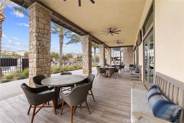 view of patio featuring a ceiling fan, outdoor dining space, and fence