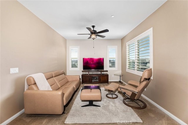 carpeted living room with a ceiling fan and baseboards