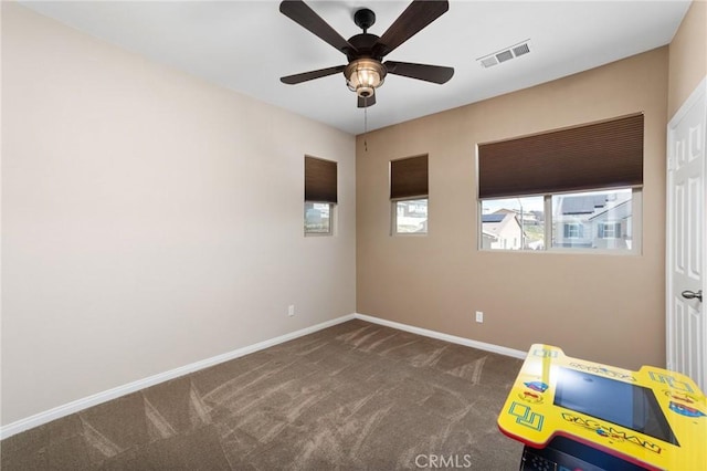 spare room featuring carpet floors, visible vents, ceiling fan, and baseboards