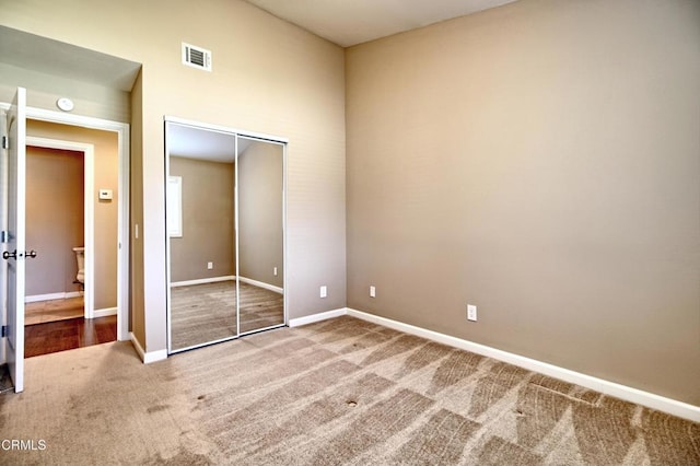 unfurnished bedroom featuring a closet, carpet flooring, visible vents, and baseboards