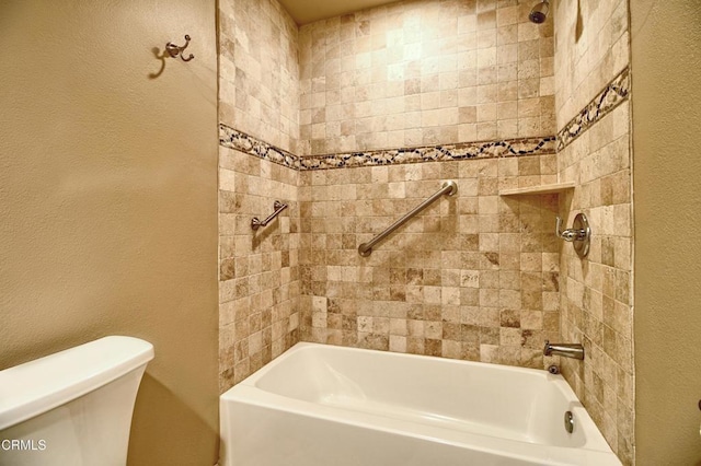 bathroom with shower / bath combination, toilet, and a textured wall