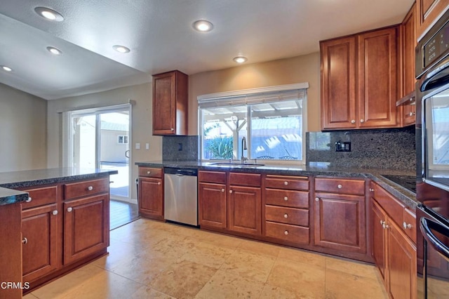 kitchen with recessed lighting, decorative backsplash, brown cabinetry, a sink, and black appliances