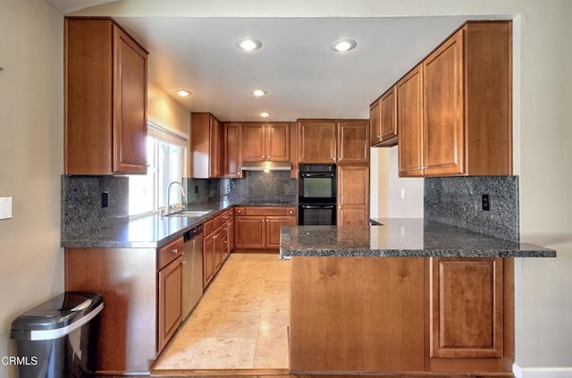 kitchen featuring a peninsula, dobule oven black, under cabinet range hood, and brown cabinets