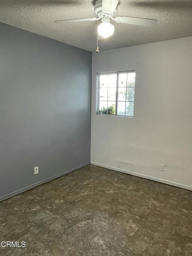 empty room with ceiling fan, a textured ceiling, and baseboards