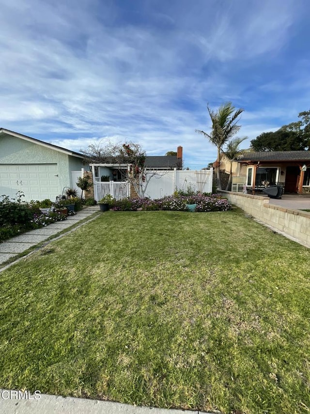 view of yard featuring fence and an attached garage