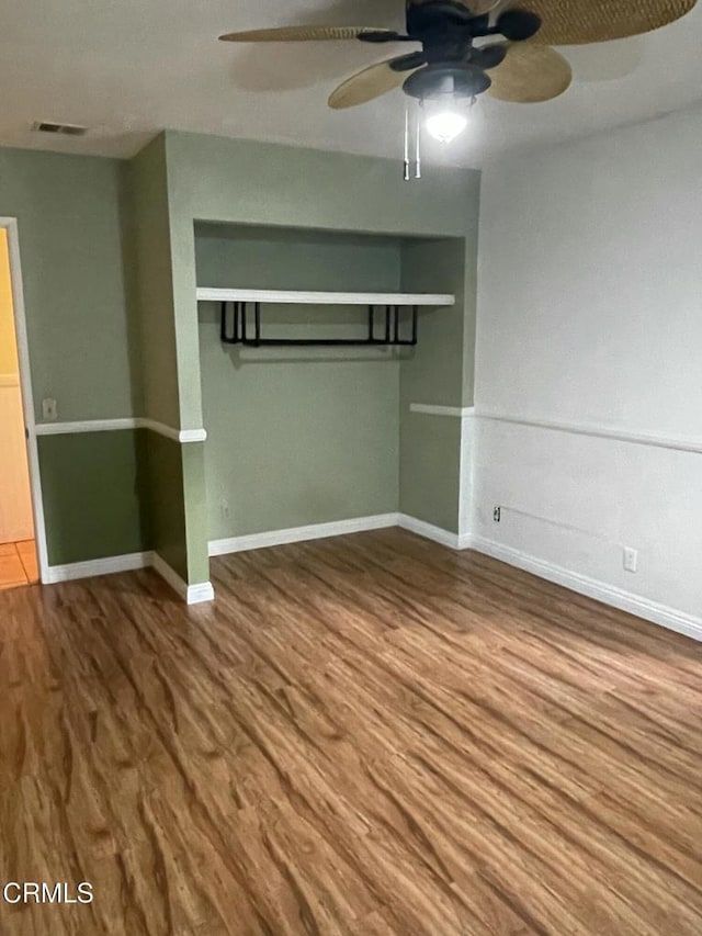 unfurnished bedroom with visible vents, ceiling fan, baseboards, and wood finished floors