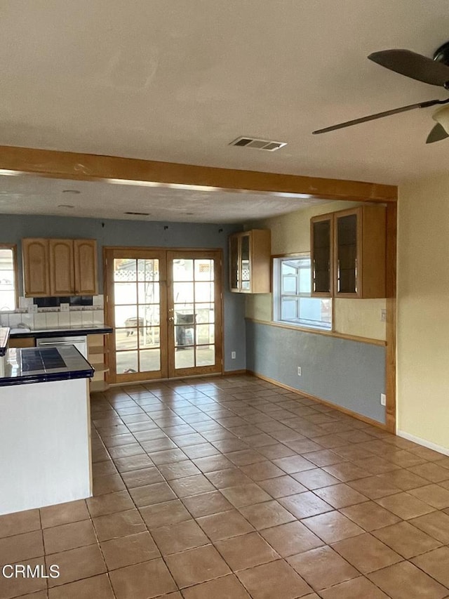 kitchen with tile countertops, light tile patterned floors, glass insert cabinets, and a wealth of natural light