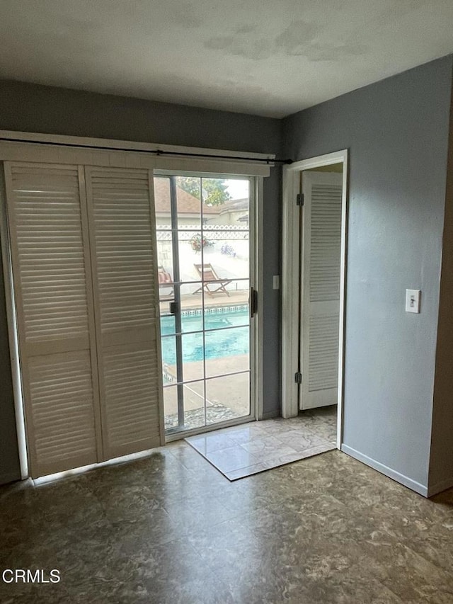 doorway to outside with concrete flooring and baseboards