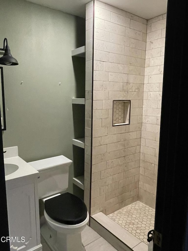 bathroom with a stall shower, vanity, and toilet