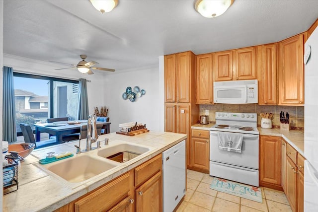 kitchen with white appliances, tile countertops, a ceiling fan, a sink, and decorative backsplash