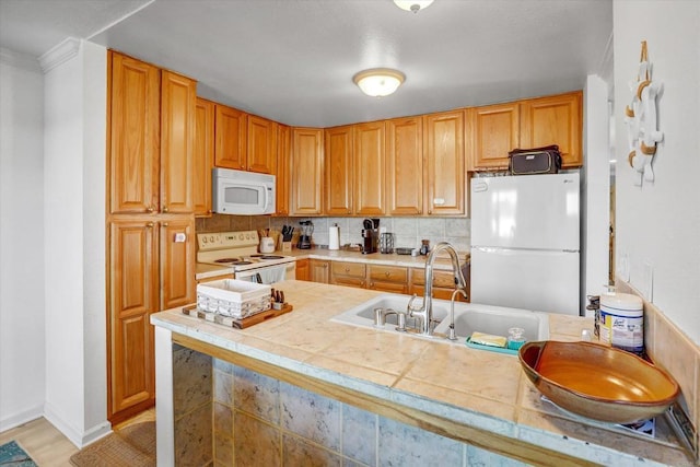 kitchen with backsplash, baseboards, light wood-type flooring, white appliances, and a sink