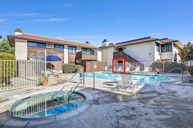 community pool featuring a patio area, a community hot tub, and fence