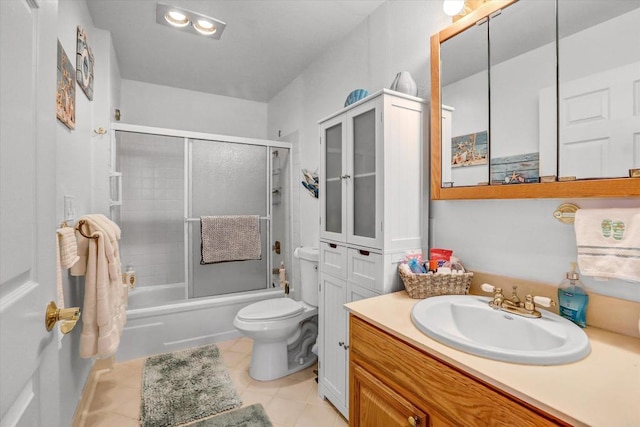 full bath with tile patterned flooring, toilet, vanity, and shower / bath combination with glass door