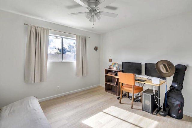 office area with a ceiling fan, baseboards, and wood finished floors