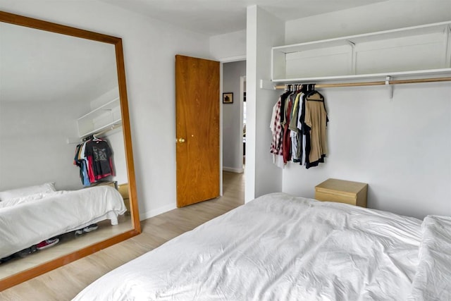 bedroom featuring baseboards, a closet, and wood finished floors