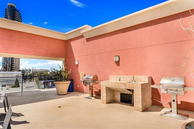 view of patio featuring a sink, a grill, and an outdoor kitchen