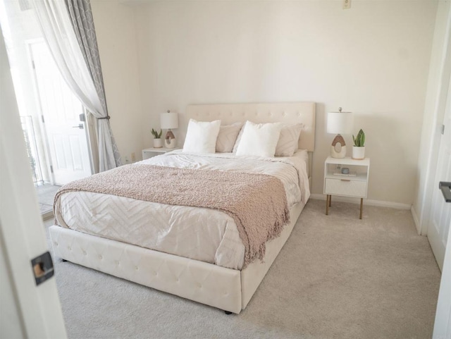 bedroom featuring baseboards and light colored carpet