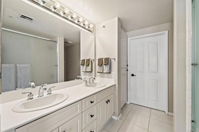 bathroom with tile patterned flooring, visible vents, a sink, and double vanity