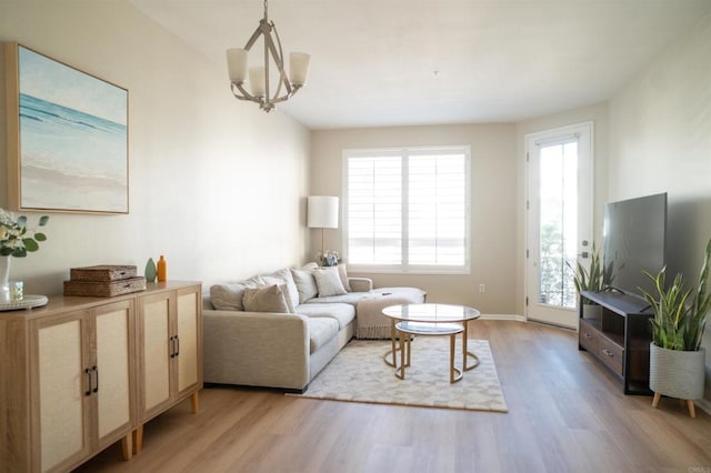 living room featuring light wood-style flooring and an inviting chandelier