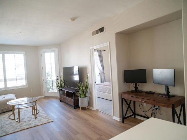 living room featuring wood finished floors, visible vents, and baseboards