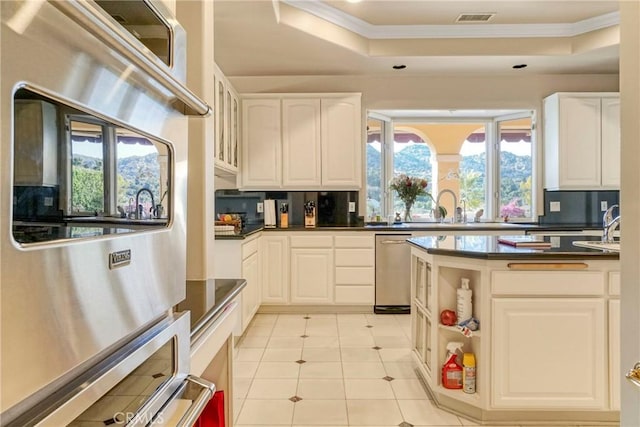 22537 N Summit Ridge Cir, Chatsworth, CA 91311 - kitchen with a raised ceiling, a sink, crown molding, dark countertops, and white cabinetry