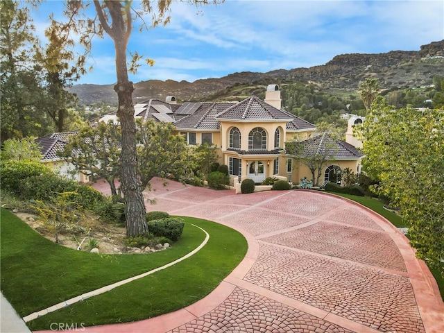 22537 N Summit Ridge Cir, Chatsworth, CA 91311 - mediterranean / spanish home featuring a chimney, stucco siding, a mountain view, and curved driveway
