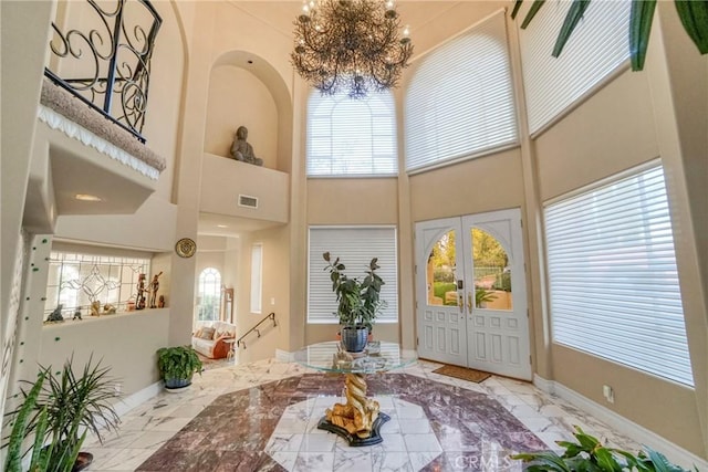 22537 N Summit Ridge Cir, Chatsworth, CA 91311 - foyer entrance featuring marble tiled flooring, a towering ceiling, baseboards, a chandelier, and french doors