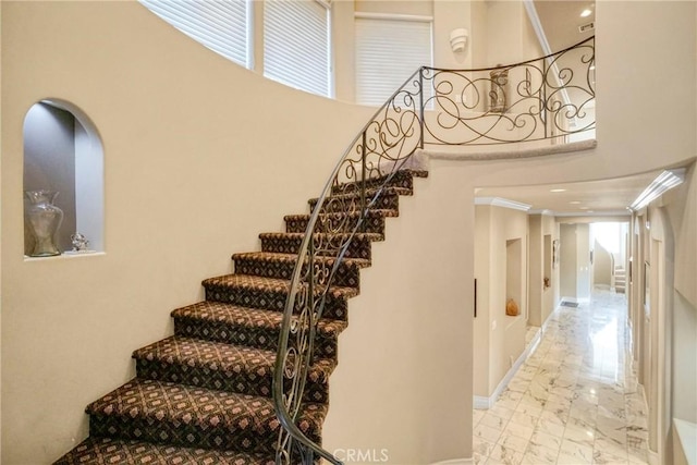 22537 N Summit Ridge Cir, Chatsworth, CA 91311 - stairs featuring marble finish floors, a towering ceiling, healthy amount of natural light, and baseboards