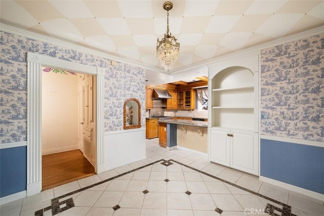 kitchen with wallpapered walls, light tile patterned floors, and wainscoting